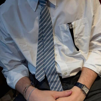 A photo of someone from the neck down wearing a white dress shirt and a blue striped tie. Their hands and waist are just out of