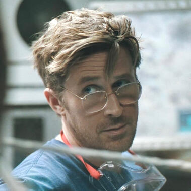 A photo of Ryland Grace from Project Hail Mary. He's looking off to the left with his eyebrow raised. He has safety goggles around his neck.